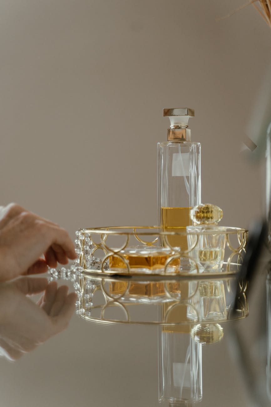 golden tray with perfume bottles standing on a mirror surface
